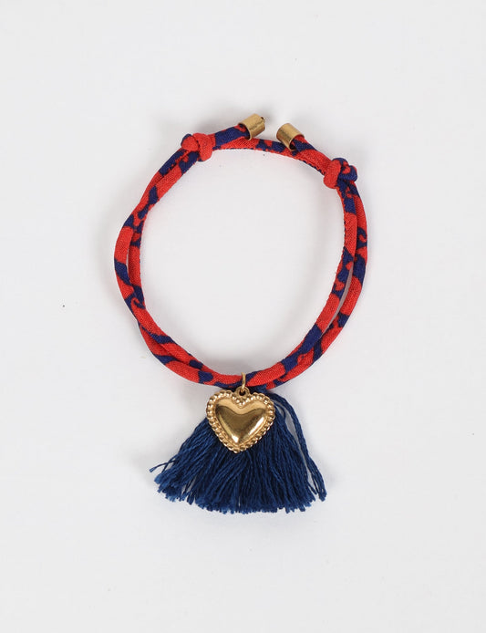 Handmade rope bracelet from recycled sari fabric with gold heart charm and tassels—eco friendly cloth, climate neutral fashion, and upcycled women’s clothing.