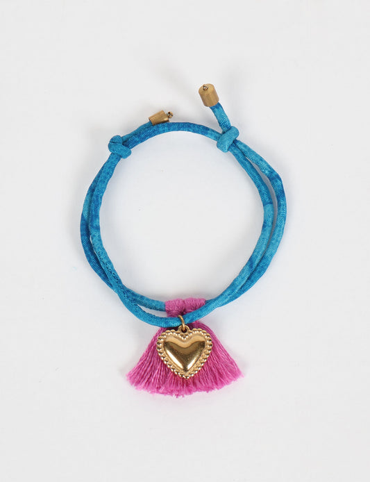 Handmade rope bracelet from recycled sari fabric with gold heart charm and tassels—eco friendly cloth, climate neutral fashion, and upcycled women’s clothing.