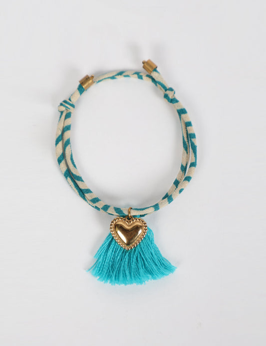 Handmade rope bracelet from recycled sari fabric with gold heart charm and tassels—eco friendly cloth, climate neutral fashion, and upcycled women’s clothing.