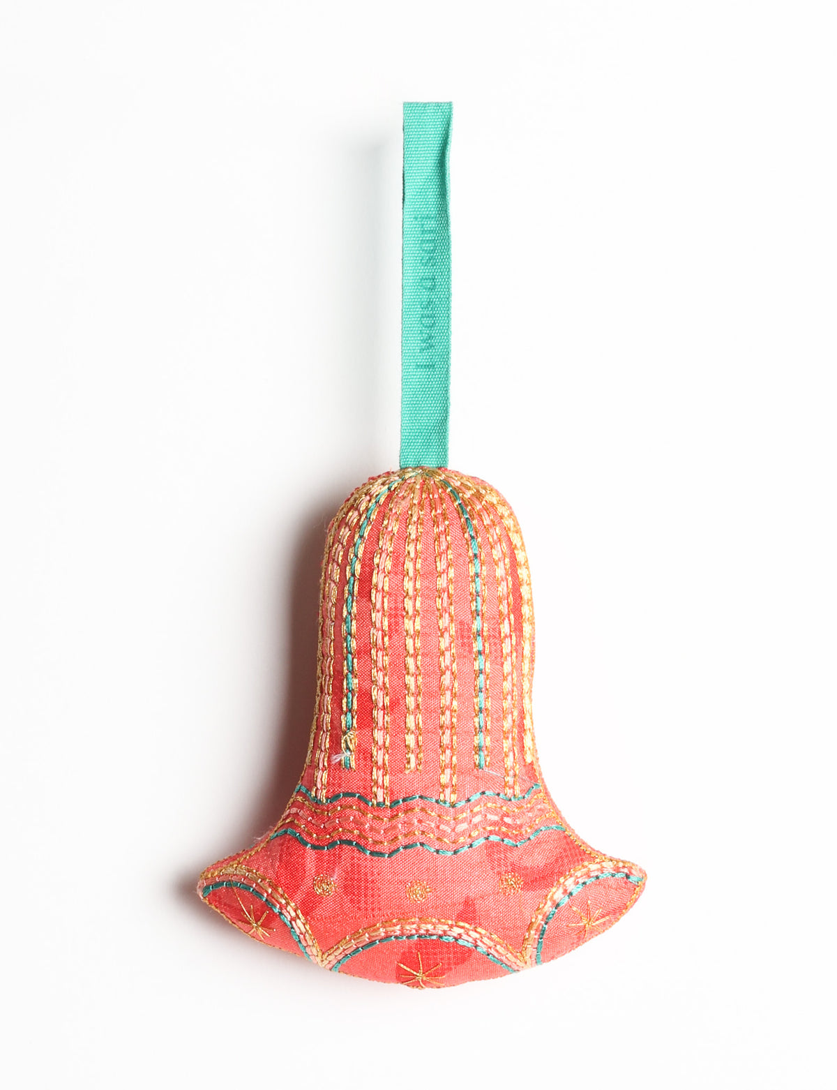 Red fabric bell ornament with gold and teal stitched details and a teal hanging loop with faint text visible