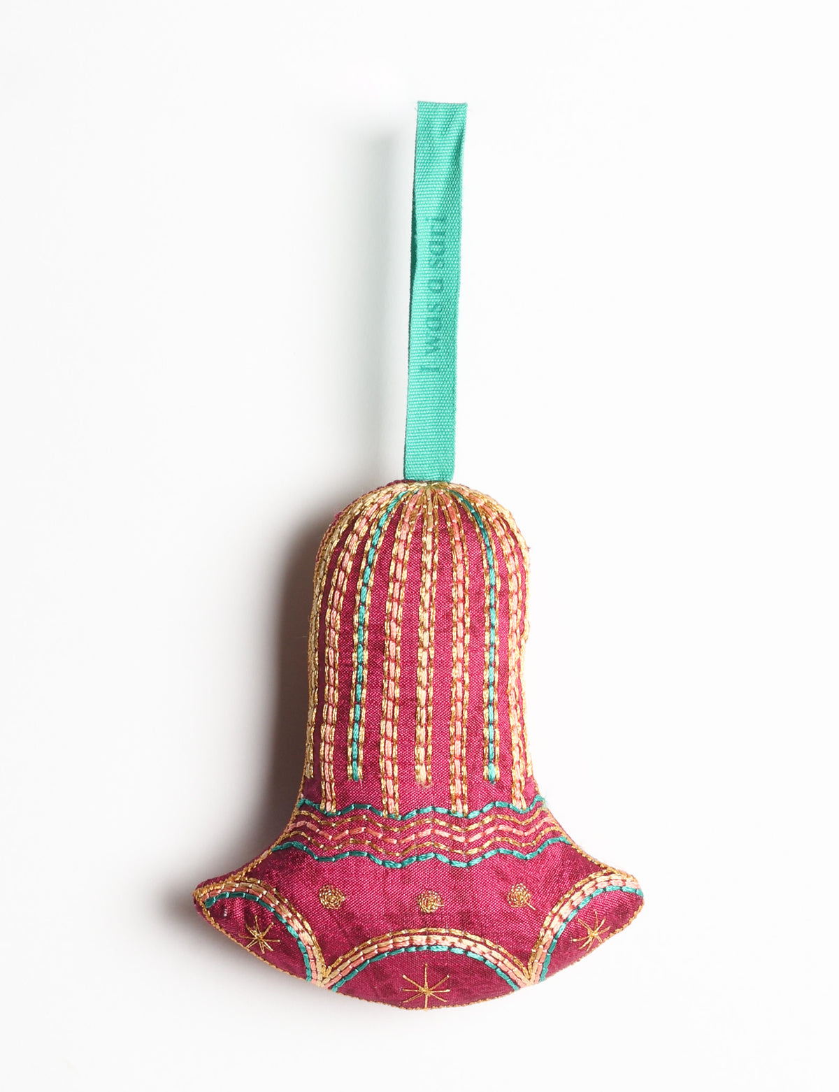 Red fabric bell ornament with gold and teal stitched details and a teal hanging loop with faint text visible