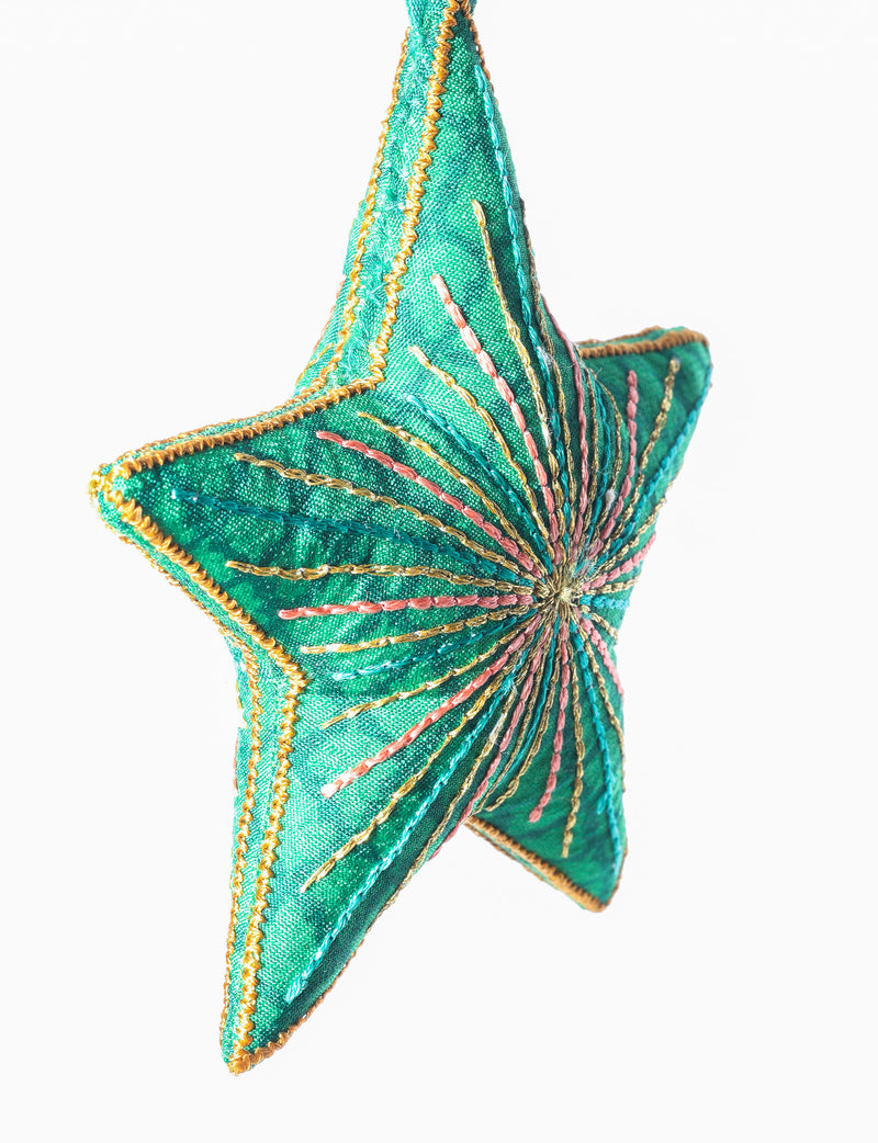 Timeless star ornament made from recycled sari fabric, featuring silk and metallic embroidery, crafted as part of green fashion, recycled clothing design, environmentally friendly clothing practices, and repurposed clothing traditions.