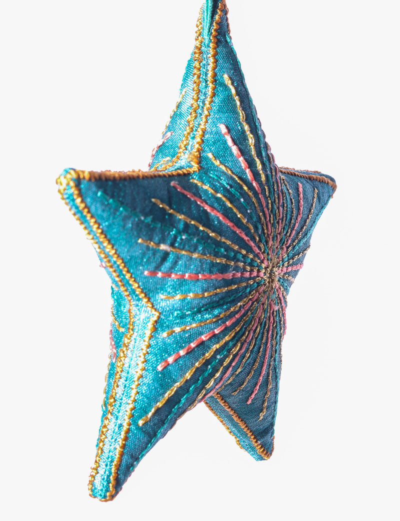 Timeless star ornament made from recycled sari fabric, featuring silk and metallic embroidery, crafted as part of green fashion, recycled clothing design, environmentally friendly clothing practices, and repurposed clothing traditions.
