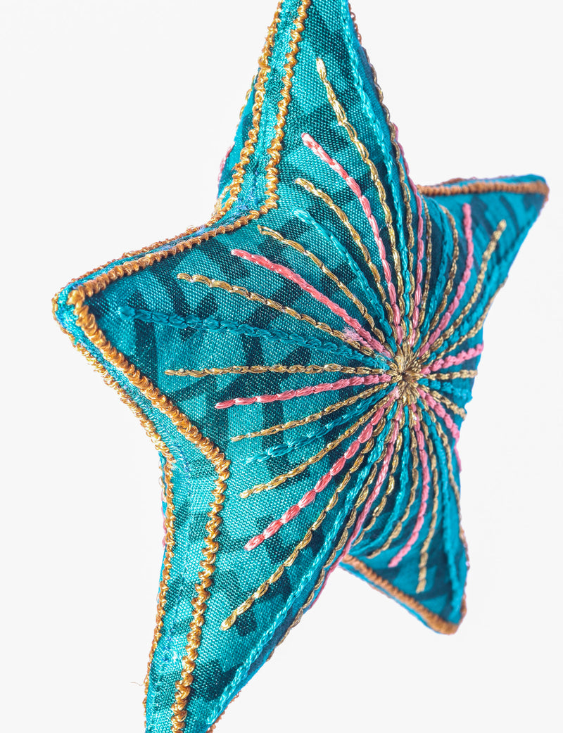 Timeless star ornament made from recycled sari fabric, featuring silk and metallic embroidery, crafted as part of green fashion, recycled clothing design, environmentally friendly clothing practices, and repurposed clothing traditions.