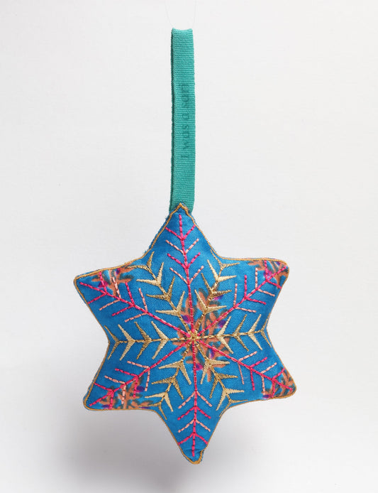 Timeless snowflake ornament made from preloved sari fabric with metallic embroidery, promoting green fashion, fair trade fashion, recycled material clothing, repurposed clothing, sustainable women's clothing, and circular fashion for a conscious lifestyle.