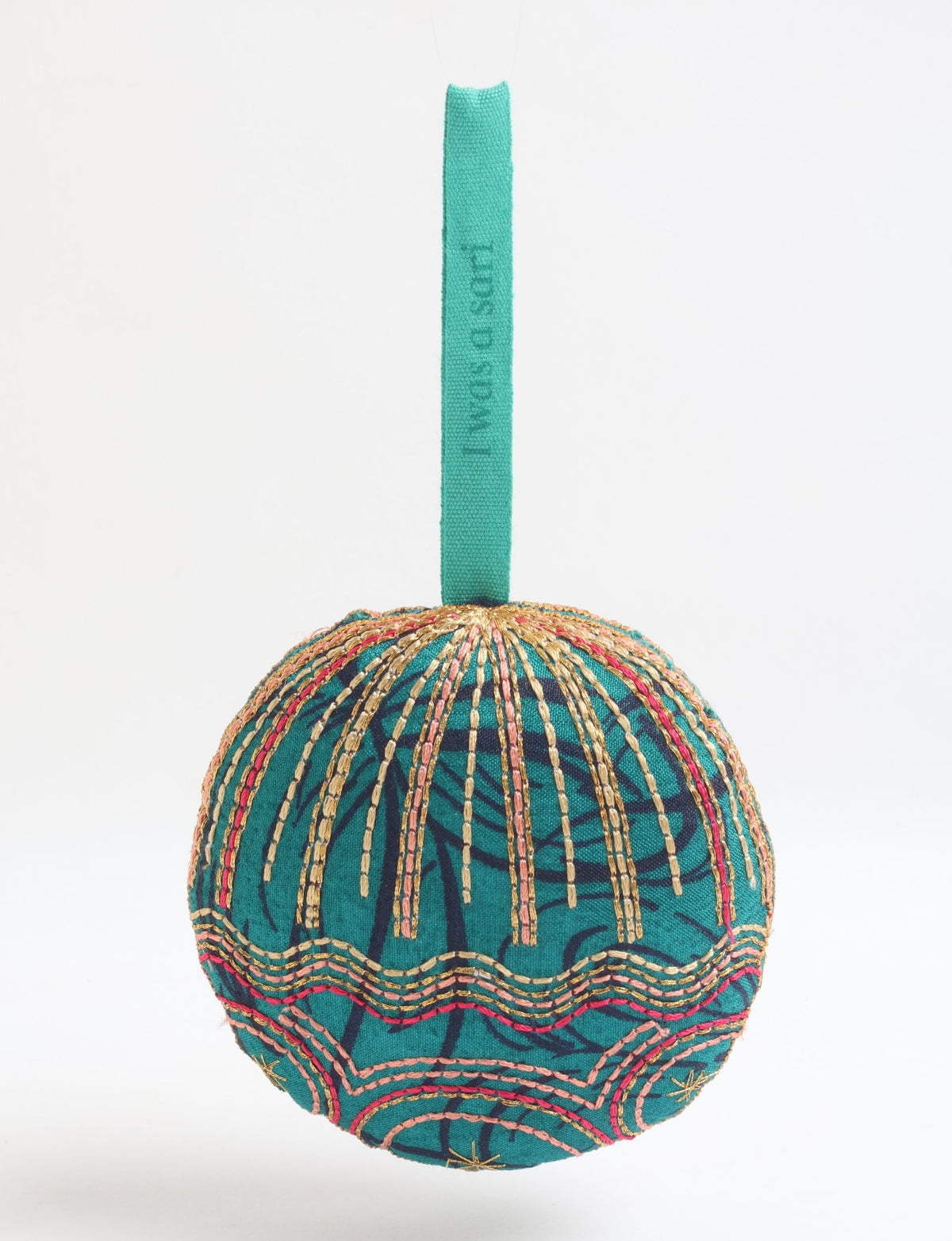 Green fabric full moon ornament with abstract dark blue pattern and gold, pink, and red stitched details, hanging by a teal loop