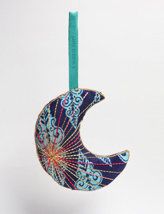 Timeless crescent moon ornament made from recycled materials and textile waste, featuring intricate embroidery. A zero waste and carbon offset accessory that supports circular fashion, fair trade fashion, and environmentally friendly clothing choices.