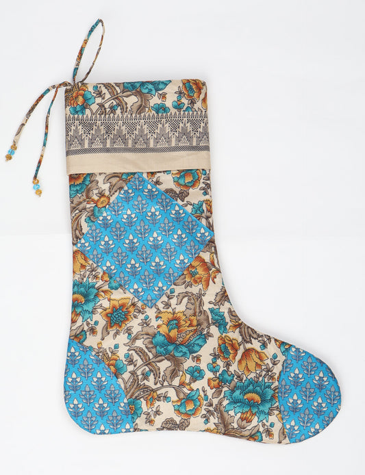 Timeless Christmas stocking made from recycled sari fabric, featuring colorful patchwork, tassel details, and crafted with care in line with circular fashion, upcycling fashion, carbon neutral clothing, and environmentally friendly clothing ideals — a beautiful piece of repurposed clothing and eco clothing for sustainable women’s fashion.