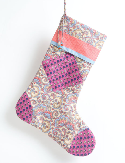 Timeless Christmas stocking made from recycled sari fabric, featuring colorful patchwork, tassel details, and crafted with care in line with circular fashion, upcycling fashion, carbon neutral clothing, and environmentally friendly clothing ideals — a beautiful piece of repurposed clothing and eco clothing for sustainable women’s fashion.