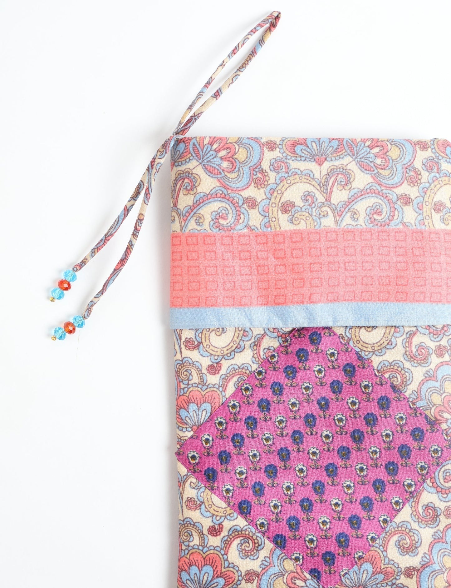 Timeless Christmas stocking made from recycled sari fabric, featuring colorful patchwork, tassel details, and crafted with care in line with circular fashion, upcycling fashion, carbon neutral clothing, and environmentally friendly clothing ideals — a beautiful piece of repurposed clothing and eco clothing for sustainable women’s fashion.