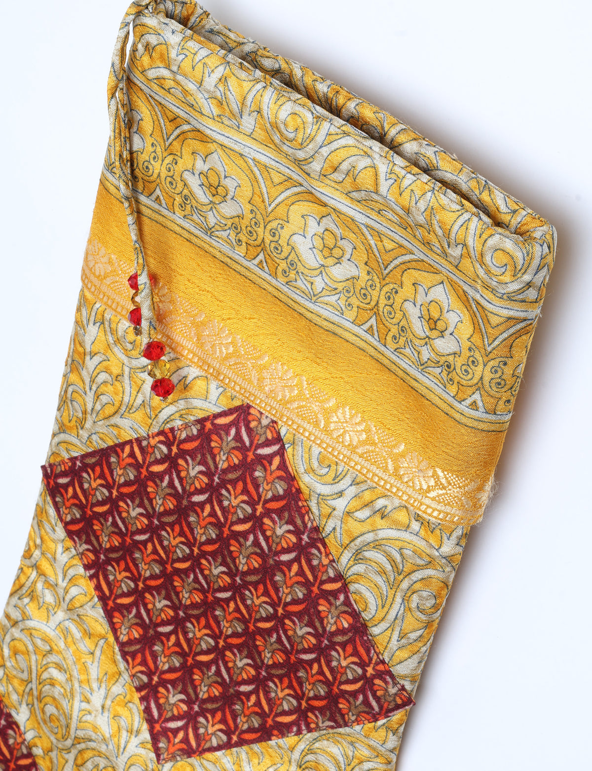 Timeless Christmas stocking made from recycled sari fabric, featuring colorful patchwork, tassel details, and crafted with care in line with circular fashion, upcycling fashion, carbon neutral clothing, and environmentally friendly clothing ideals — a beautiful piece of repurposed clothing and eco clothing for sustainable women’s fashion.