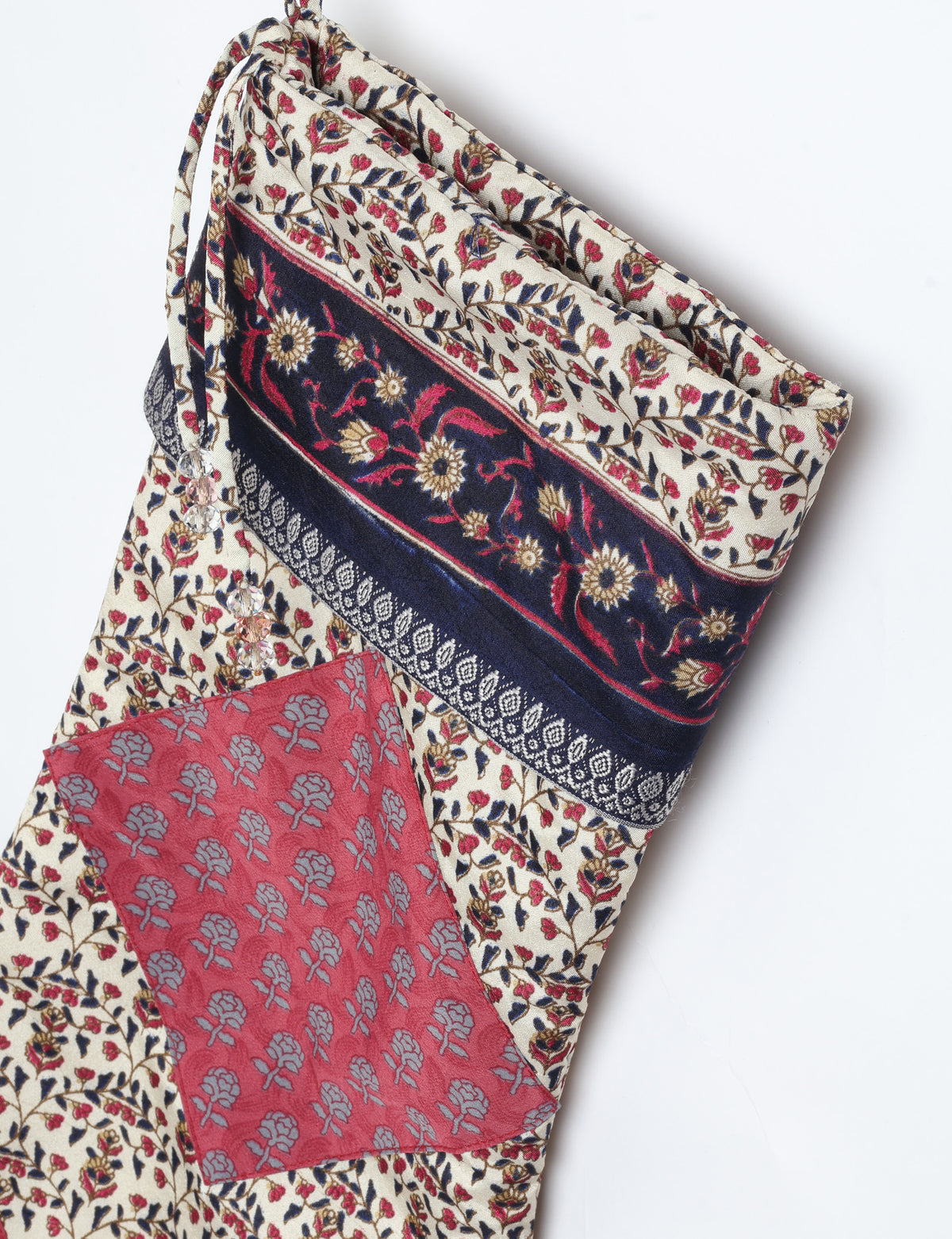 Timeless Christmas stocking made from recycled sari fabric, featuring colorful patchwork, tassel details, and crafted with care in line with circular fashion, upcycling fashion, carbon neutral clothing, and environmentally friendly clothing ideals — a beautiful piece of repurposed clothing and eco clothing for sustainable women’s fashion.