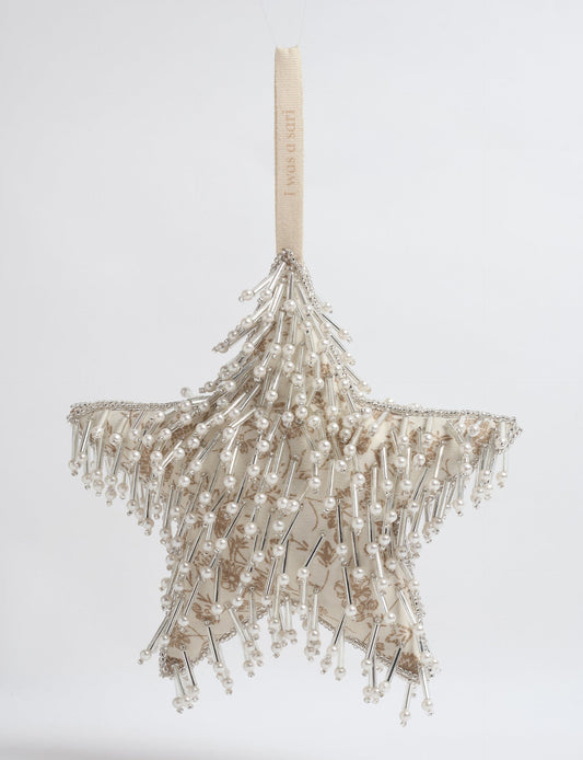 Upcycled silver star Christmas ornament made from recycled sari fabric, hand embroidered with sequins, pearls, and glass beads — a fair trade, slow fashion, and zero waste clothing accessory.