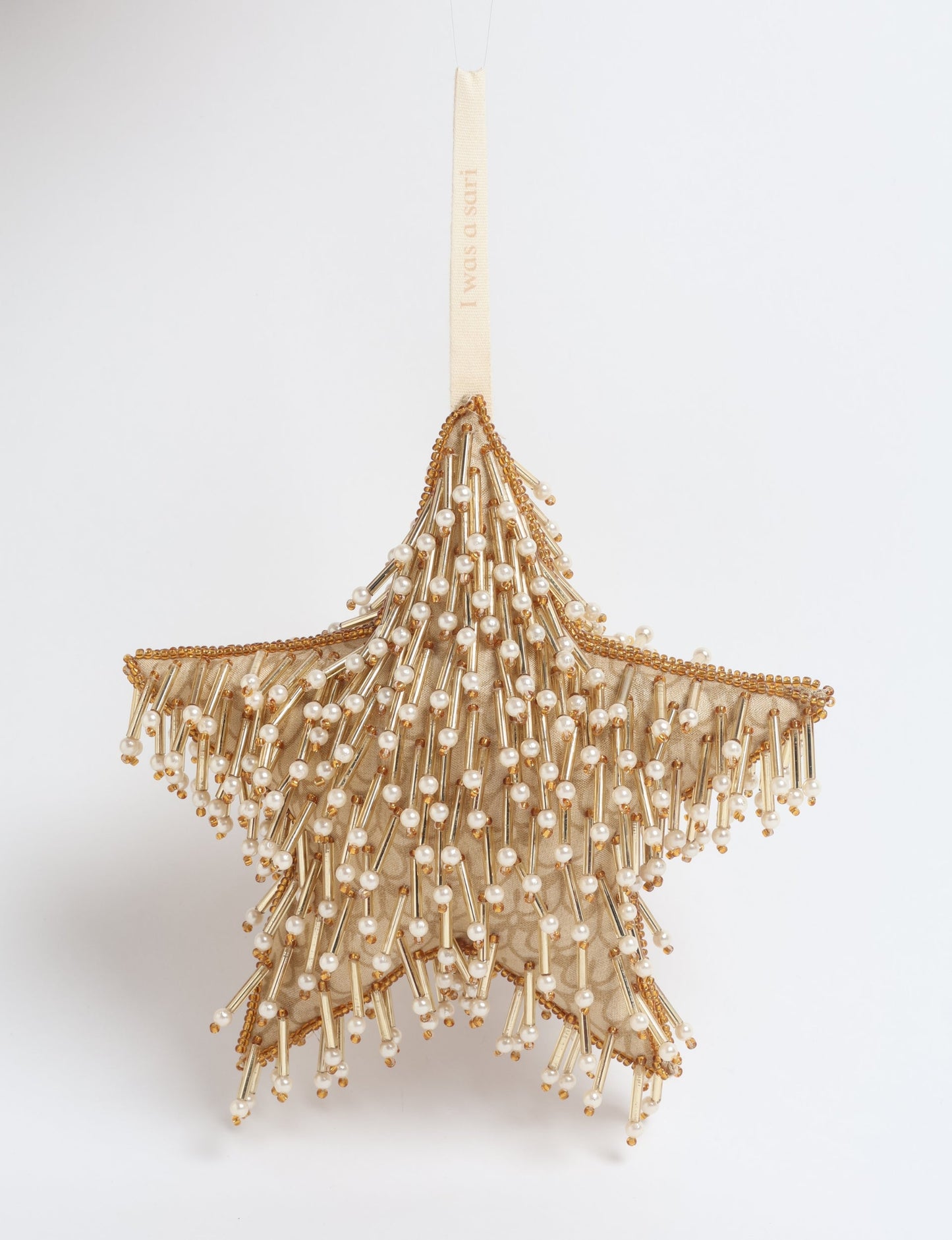 Gold colored star ornament made from ivory and gold preloved saris, filled with organic cotton and decorated with silver hand embroidery, representing upcycled clothing, green fashion, fair trade fashion, recycled material clothing, repurposed clothing, climate neutral clothing, eco clothing, second hand clothing, recycled sustainable fashion, and sustainable women’s clothing.