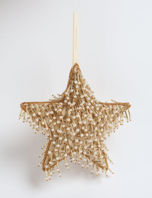 Gold colored star ornament made from ivory and gold preloved saris, filled with organic cotton and decorated with silver hand embroidery, representing upcycled clothing, green fashion, fair trade fashion, recycled material clothing, repurposed clothing, climate neutral clothing, eco clothing, second hand clothing, recycled sustainable fashion, and sustainable women’s clothing.