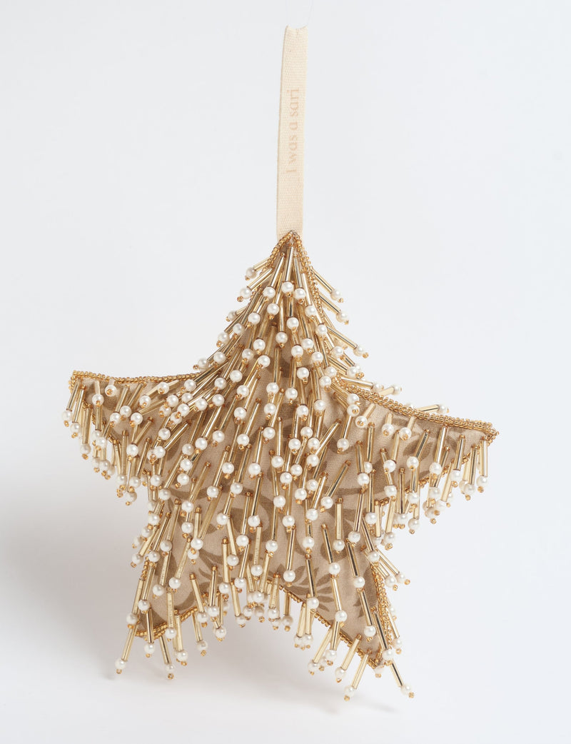 Beige star ornament decorated with gold beads and small white pearls, hanging by a beige fabric loop with text