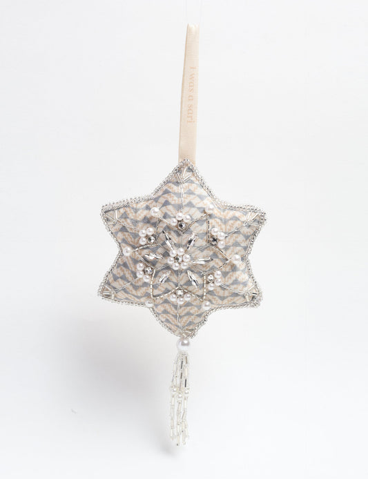 Silver snowflake ornament made from ivory and grey recycled sari products, enhanced with silver beads and pearls. Designed for lovers of eco friendly products, climate neutral clothing, and repurposed clothing, supporting zero waste clothing and conscious clothing movements.