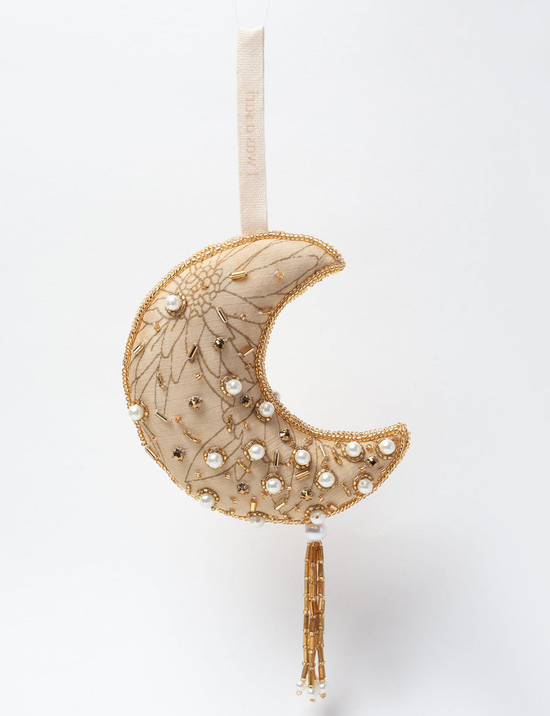 Gold crescent moon ornament with floral embroidery, pearl and gold bead embellishments, hanging tassel, and fabric loop
