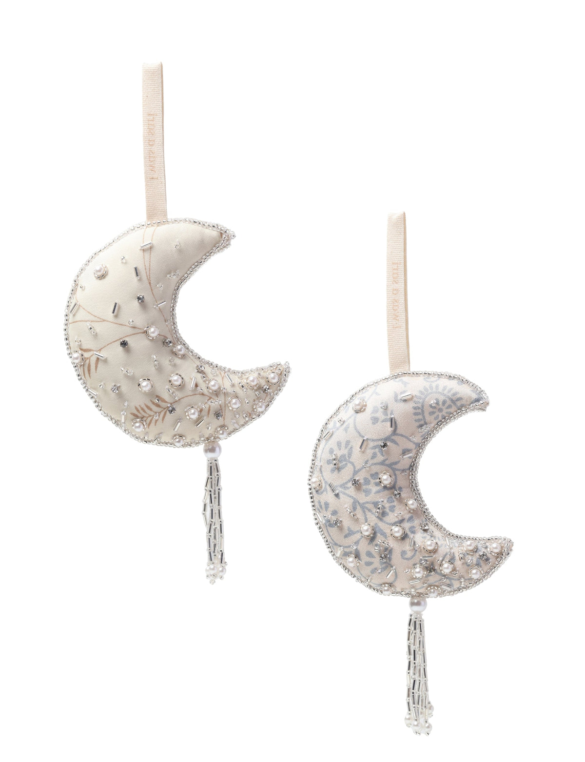 Set of two silver crescent moon ornaments with pearl and bead embellishments, fabric loops, and hanging tassels, front view