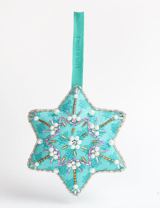 Upcycled snowflake Christmas ornament made from repurposed saris and hand-embroidered with Aari work using donated beads and stones — a conscious piece of eco clothing reflecting fair trade, green fashion, and sustainable women’s clothing ideals.