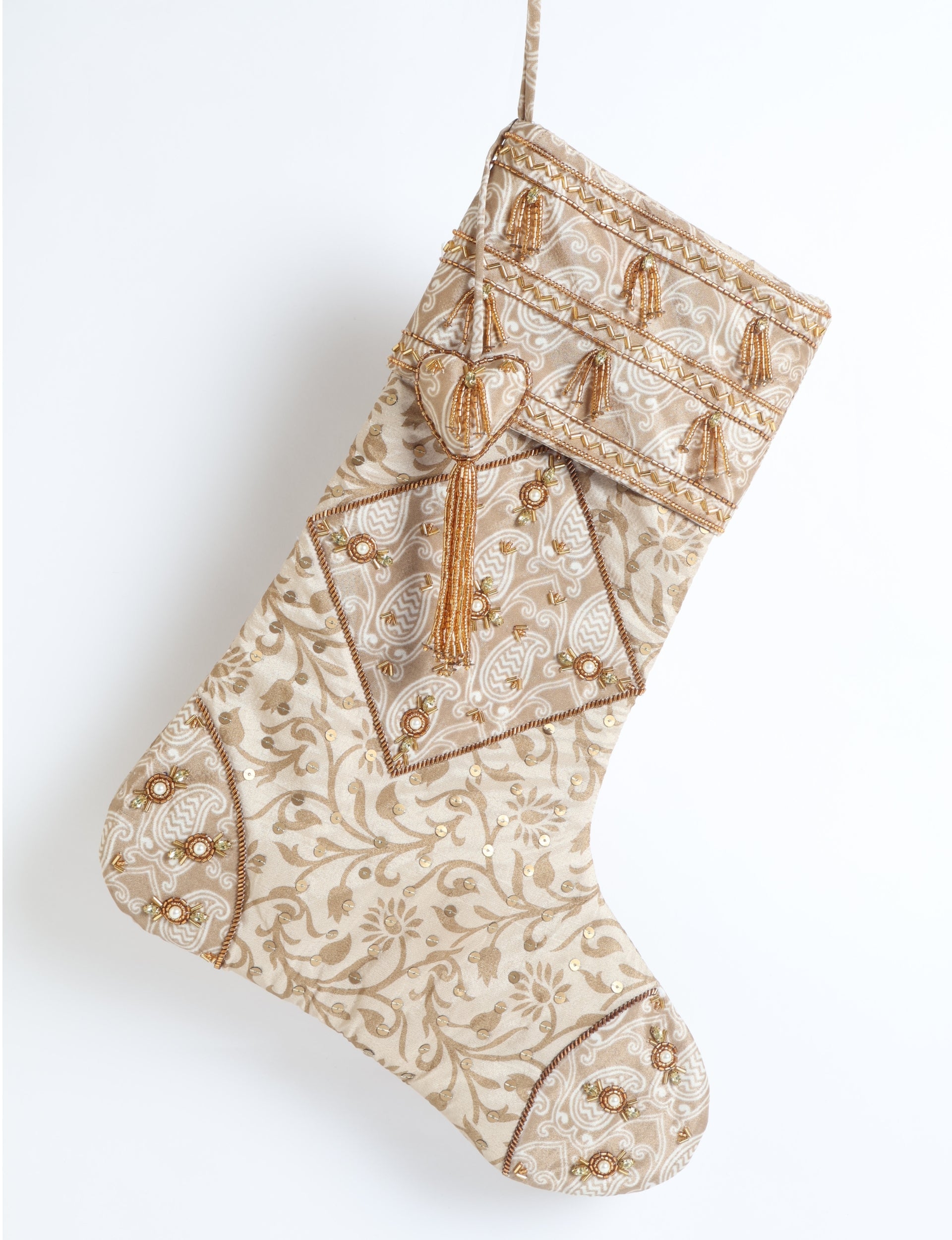 Beige patchwork Christmas stocking with leaf patterns, gold bead tassels, sequins, and embroidered details, hanging view