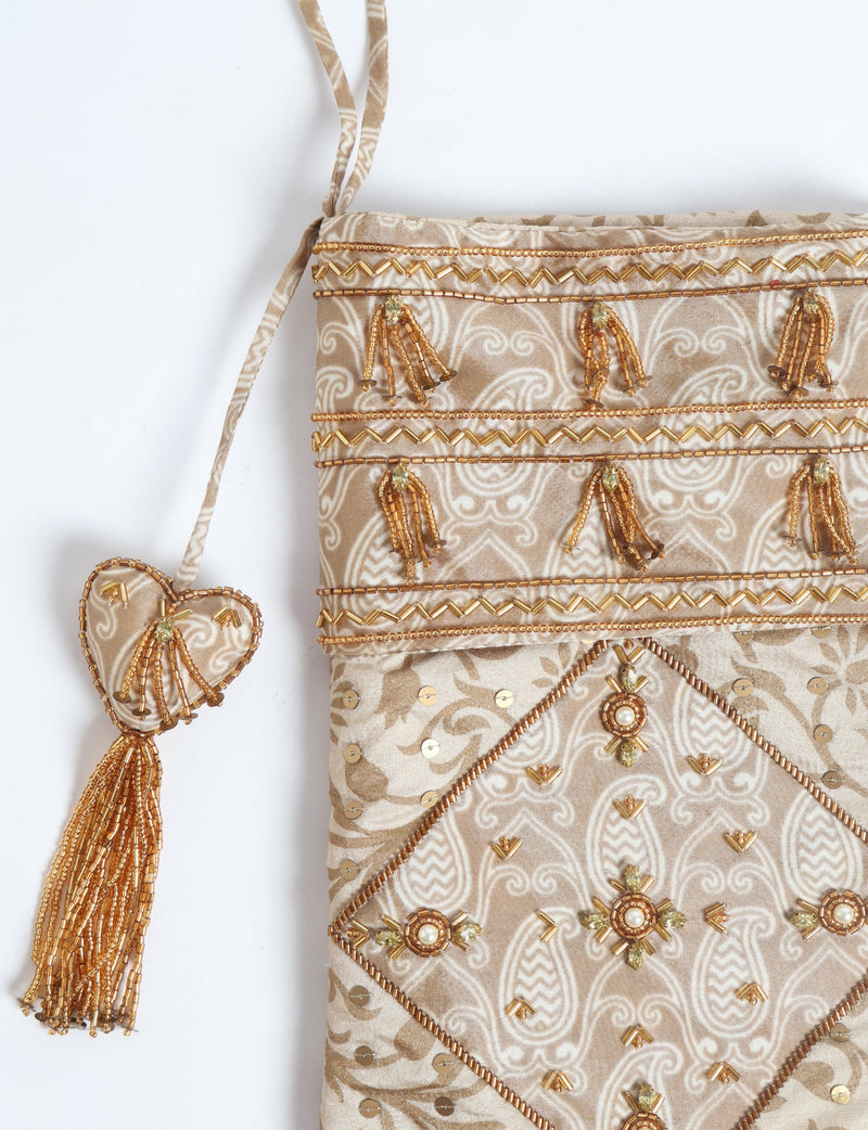 Beige patchwork Christmas stocking with leaf pattern, gold bead embellishments, sequins, and a heart-shaped tassel hanging loop