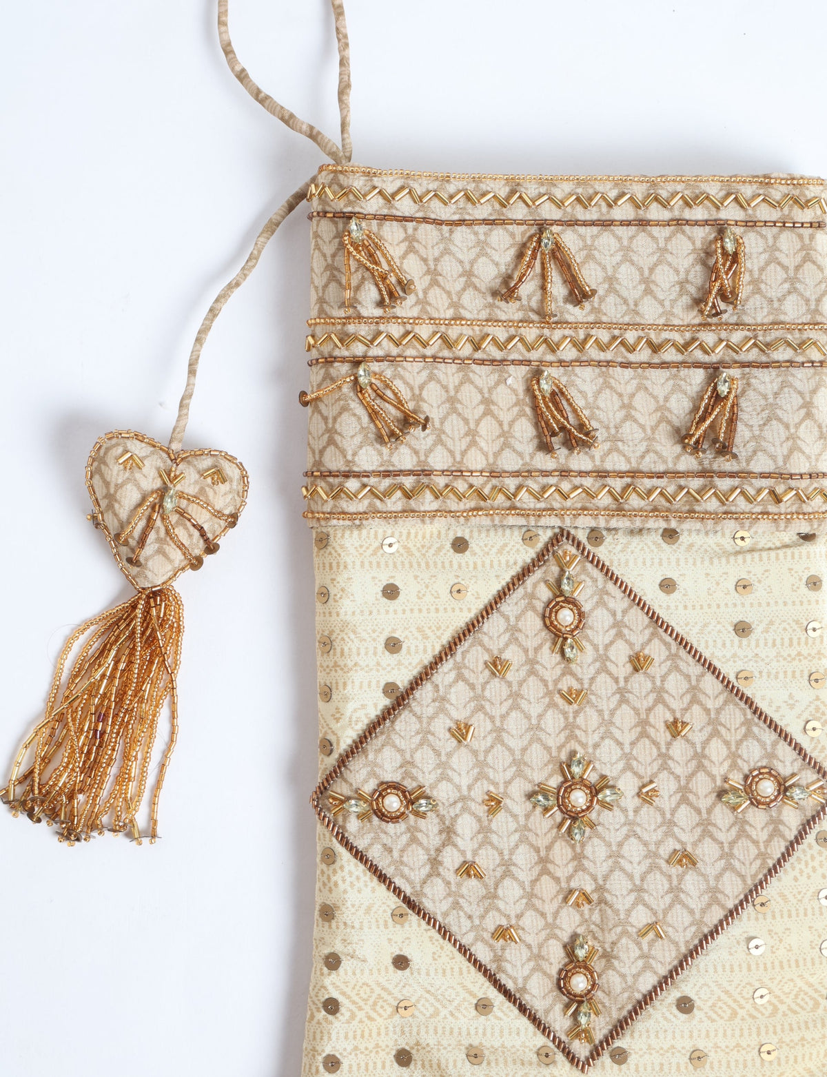 Beige paisley patchwork Christmas stocking with gold bead and sequin embellishments, hanging with a beaded tassel heart detail