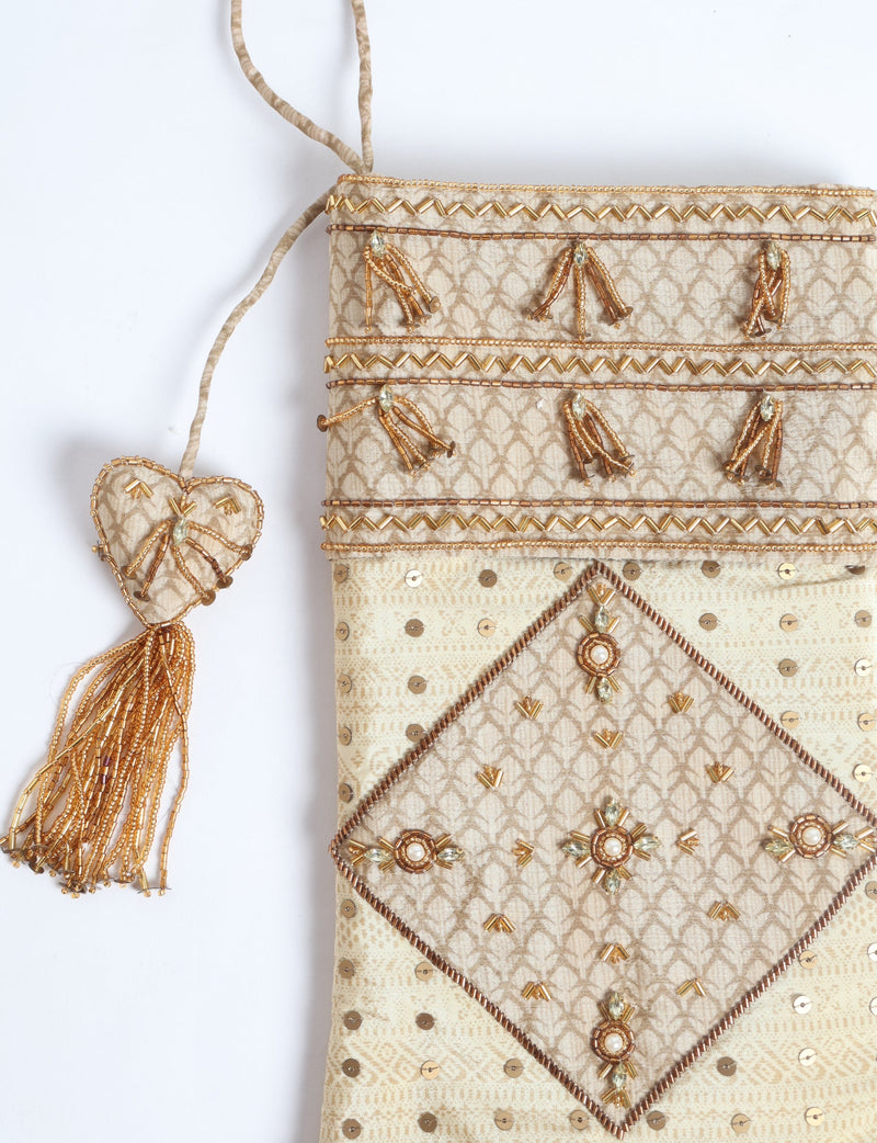 Beige paisley patchwork Christmas stocking with gold bead and sequin embellishments, hanging with a beaded tassel heart detail