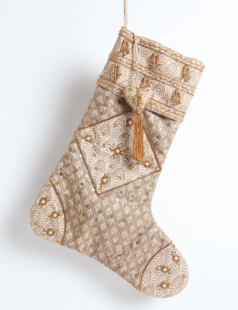 Beige patchwork Christmas stocking with micro leaf pattern, gold sequins, bead tassels, and heart embellishment, hanging flat