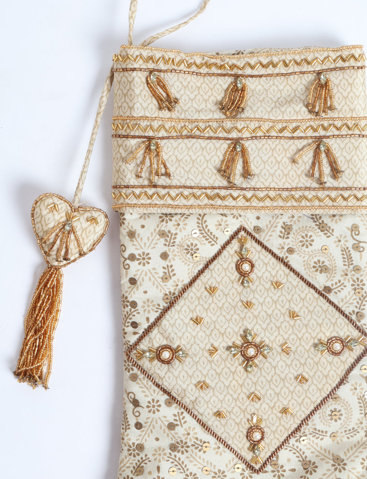 Beige patchwork Christmas stocking with gold bead and sequin embellishments and a heart-shaped tassel hanging loop