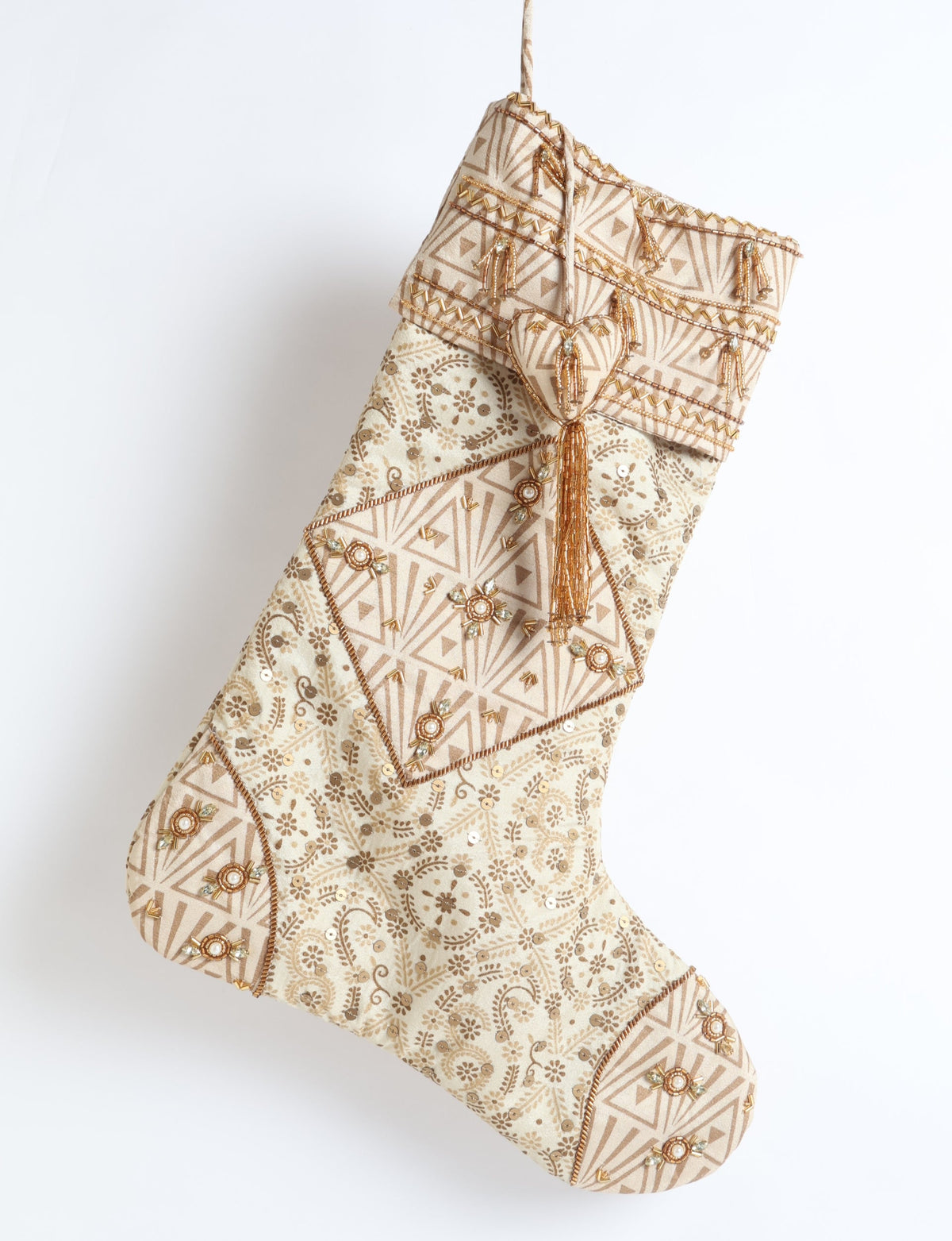 Beige patchwork Christmas stocking with leaf and geometric patterns, gold bead embellishments, and hanging loop, front view