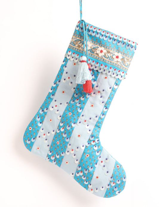 Upcycled sari Christmas stocking with striped cotton accents and hand-embroidered embellishments, reflecting green fashion, zero-waste clothing, recycled fashion, repurposed clothing, carbon-neutral fashion, natural clothing, conscious clothing, and sustainable women’s clothing.