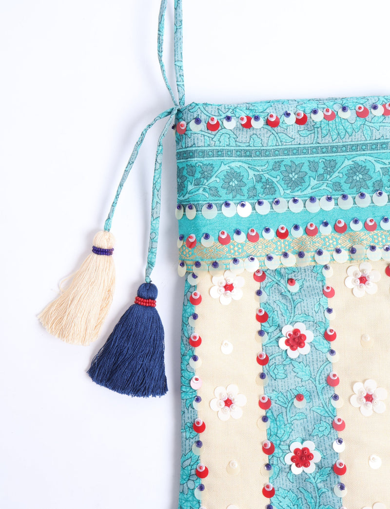 Blue and cream flower-patterned Christmas stocking with red, white, and blue sequins and two hanging tassels, front view