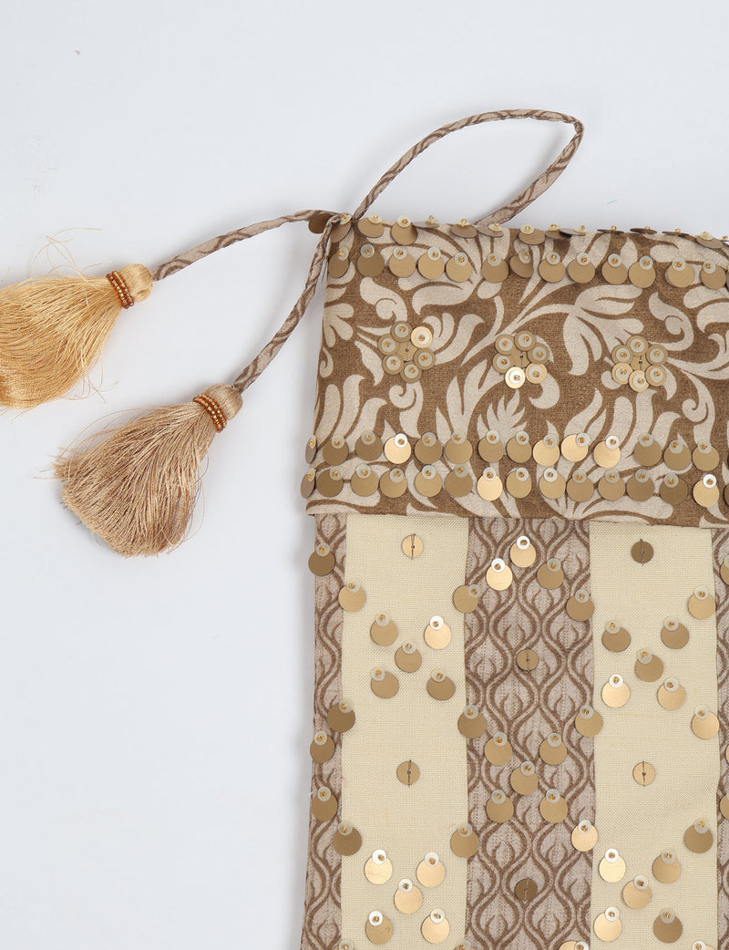 Beige and brown striped Christmas stocking with floral pattern, gold sequins, and two gold tassels on hanging loop