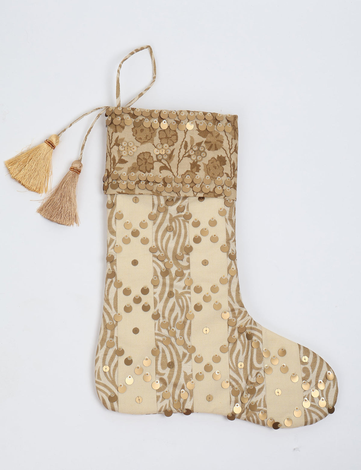 Beige and gold striped Christmas stocking with floral pattern, gold sequins, and two gold tassels on hanging loop