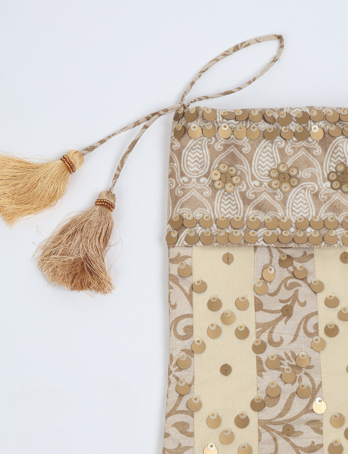 Beige and cream striped Christmas stocking with gold sequins and two gold tassels on hanging loop, flat lay view