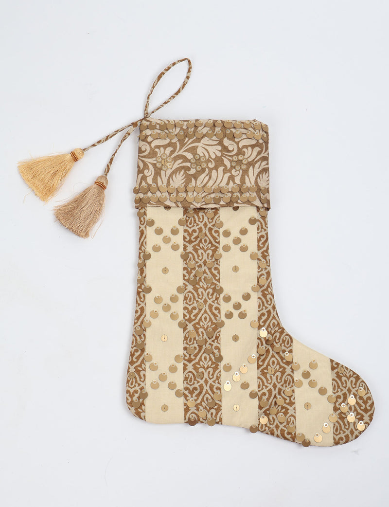 Christmas stocking with beige and brown vertical stripes, floral pattern, gold sequins, and two tassels on hanging loop
