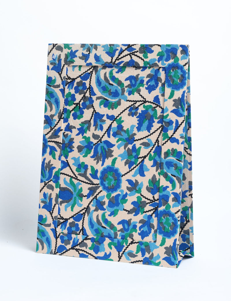 Beige tropical patterned photo frame with blue and green floral design, shown standing at an angle on white background