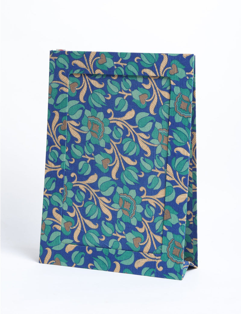 Blue tropical patterned fabric photo frame standing upright with green and beige floral leaf design, front view