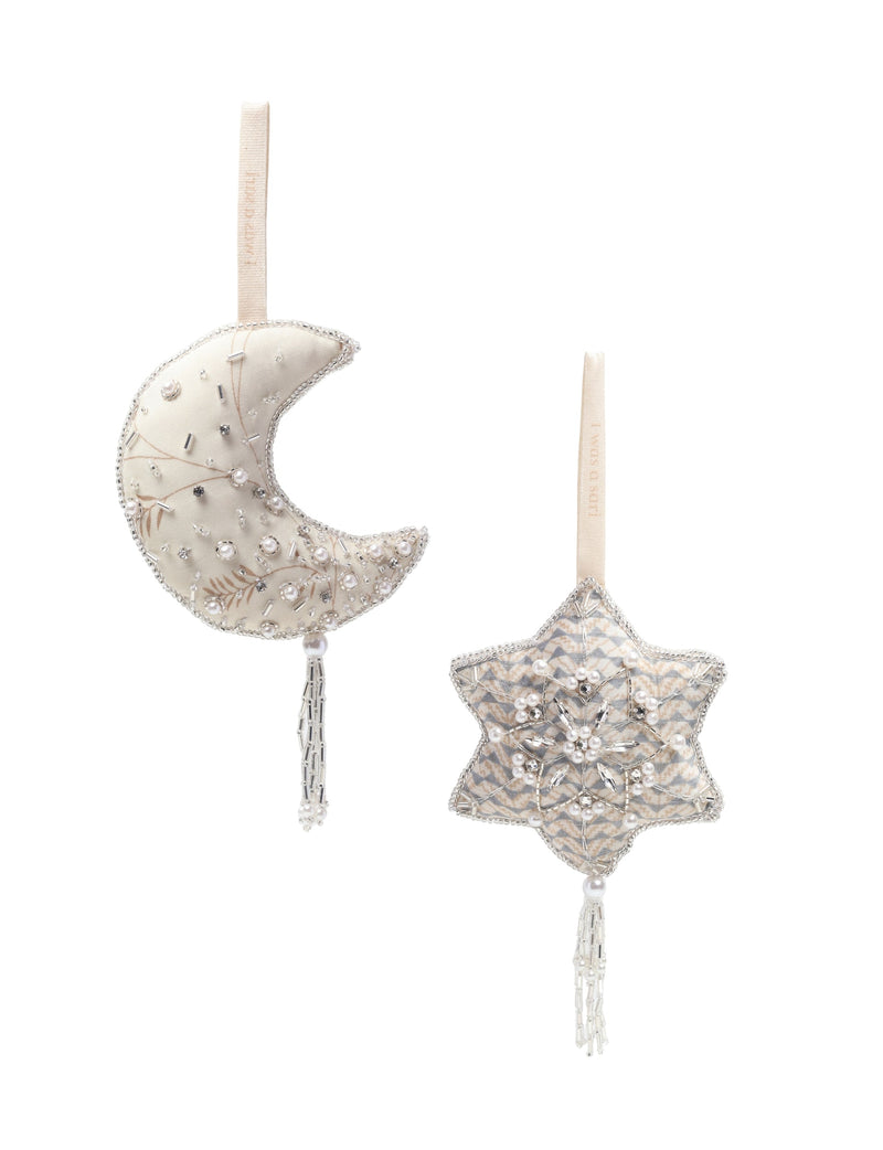 Set of two cream fabric ornaments, one crescent moon and one star, decorated with beads, pearls, and hanging tassels