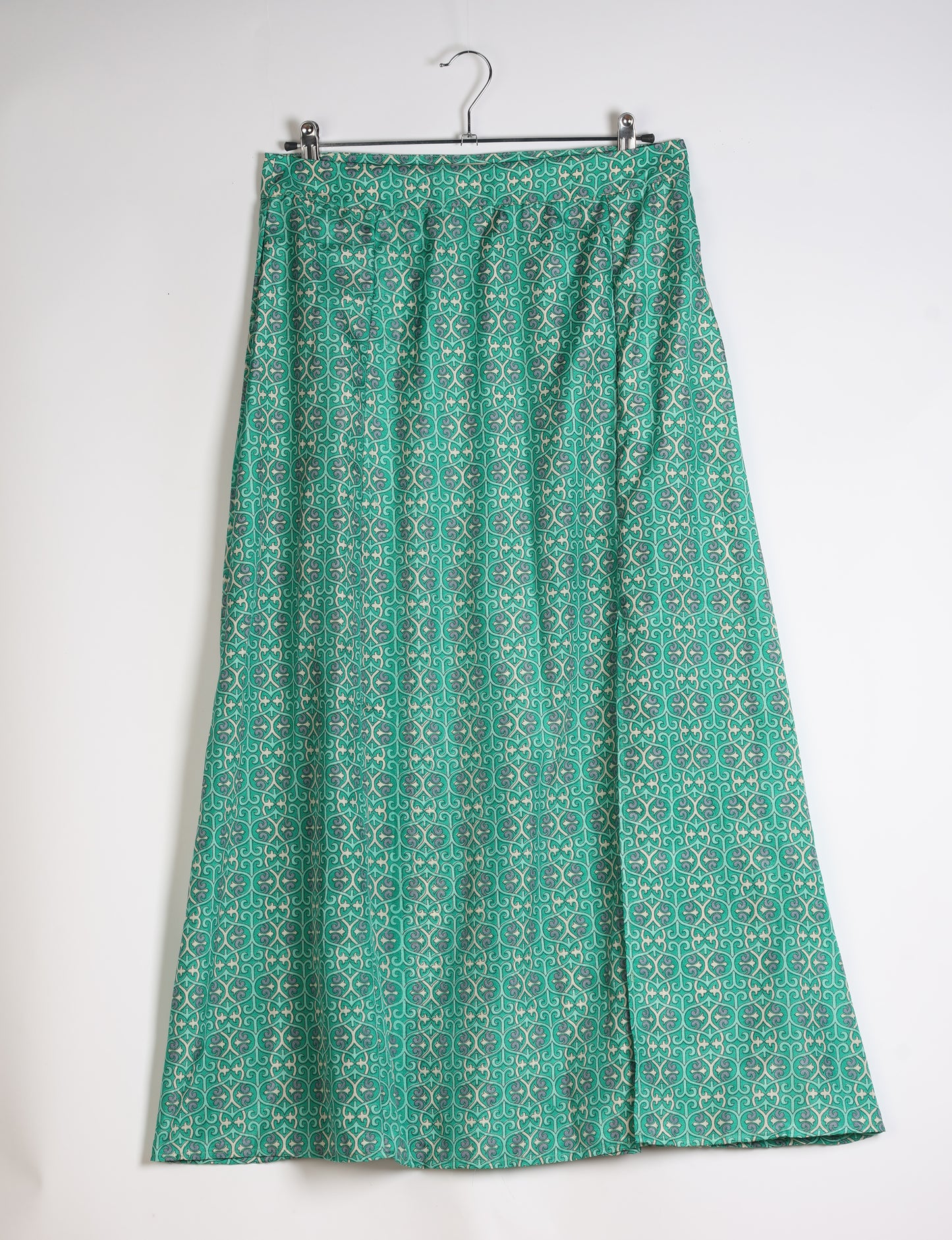 Midi A-line skirt with front slit, fitted waistband, concealed side closure, and below mid-calf length silhouette.