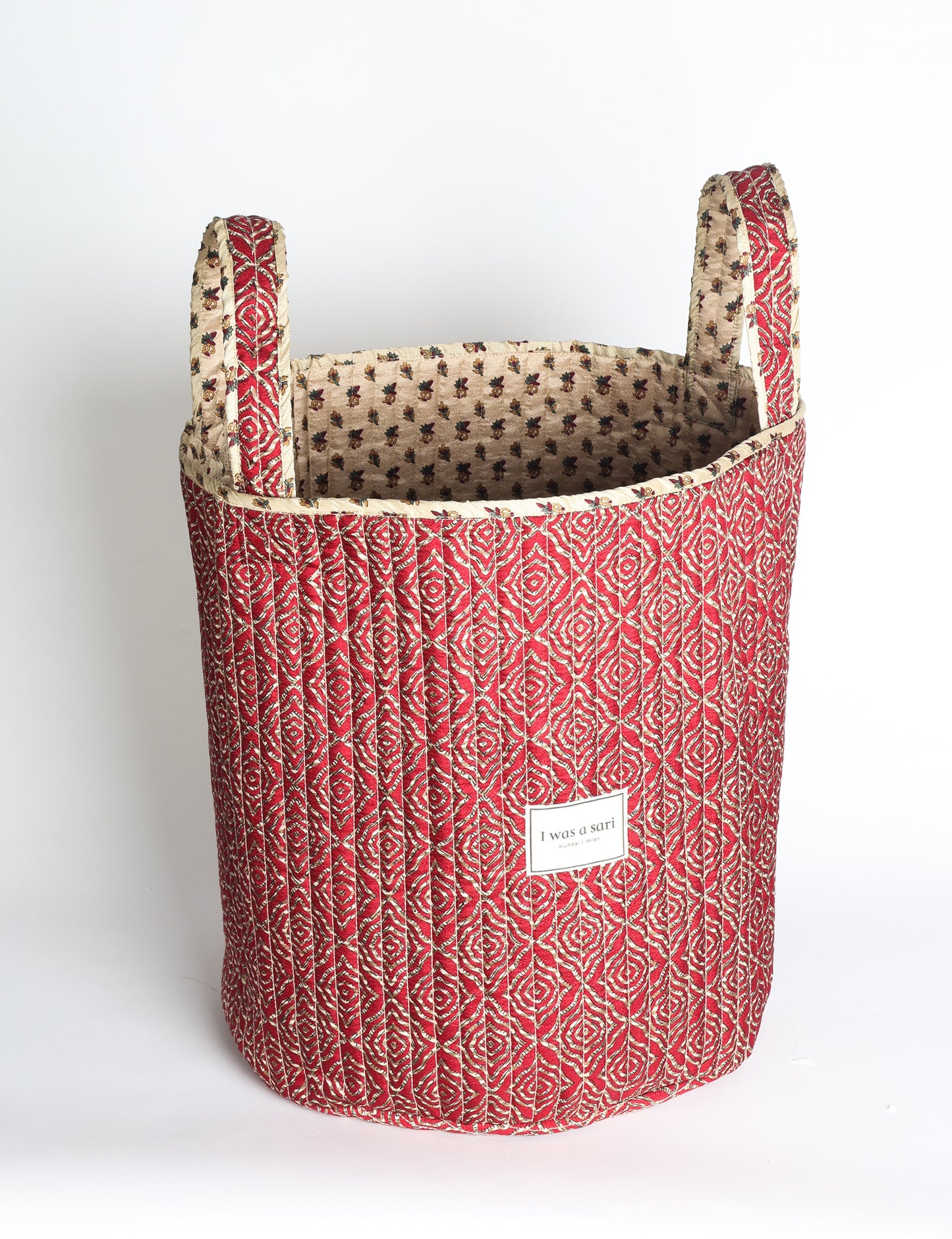 Quilted storage basket with handle in a soft cylindrical design, available in small and medium sizes for home organization.