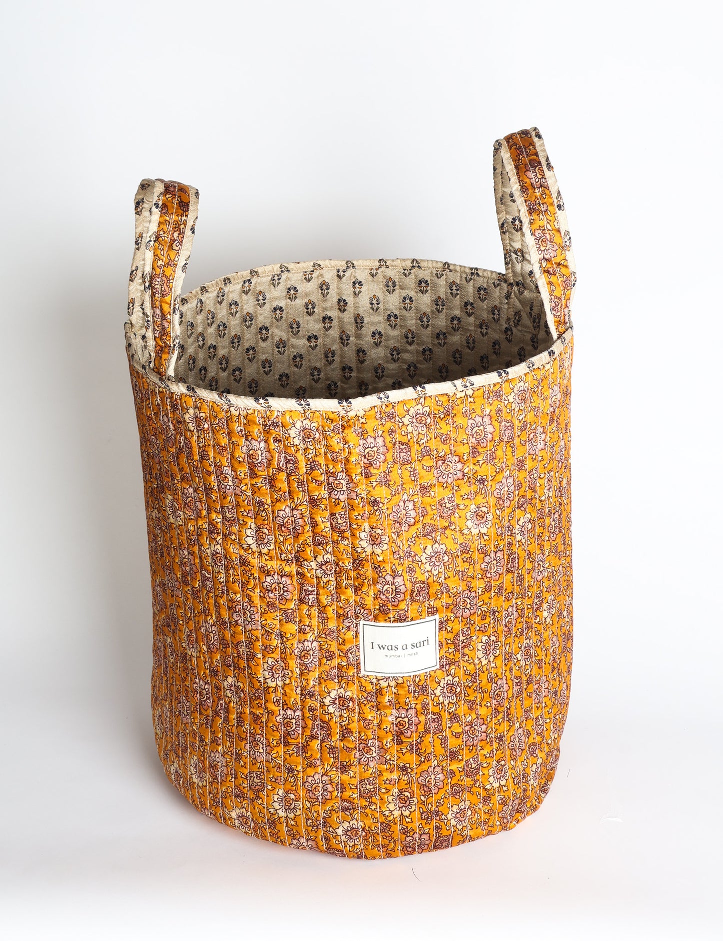 Quilted storage basket with handle in a soft cylindrical design, available in small and medium sizes for home organization.
