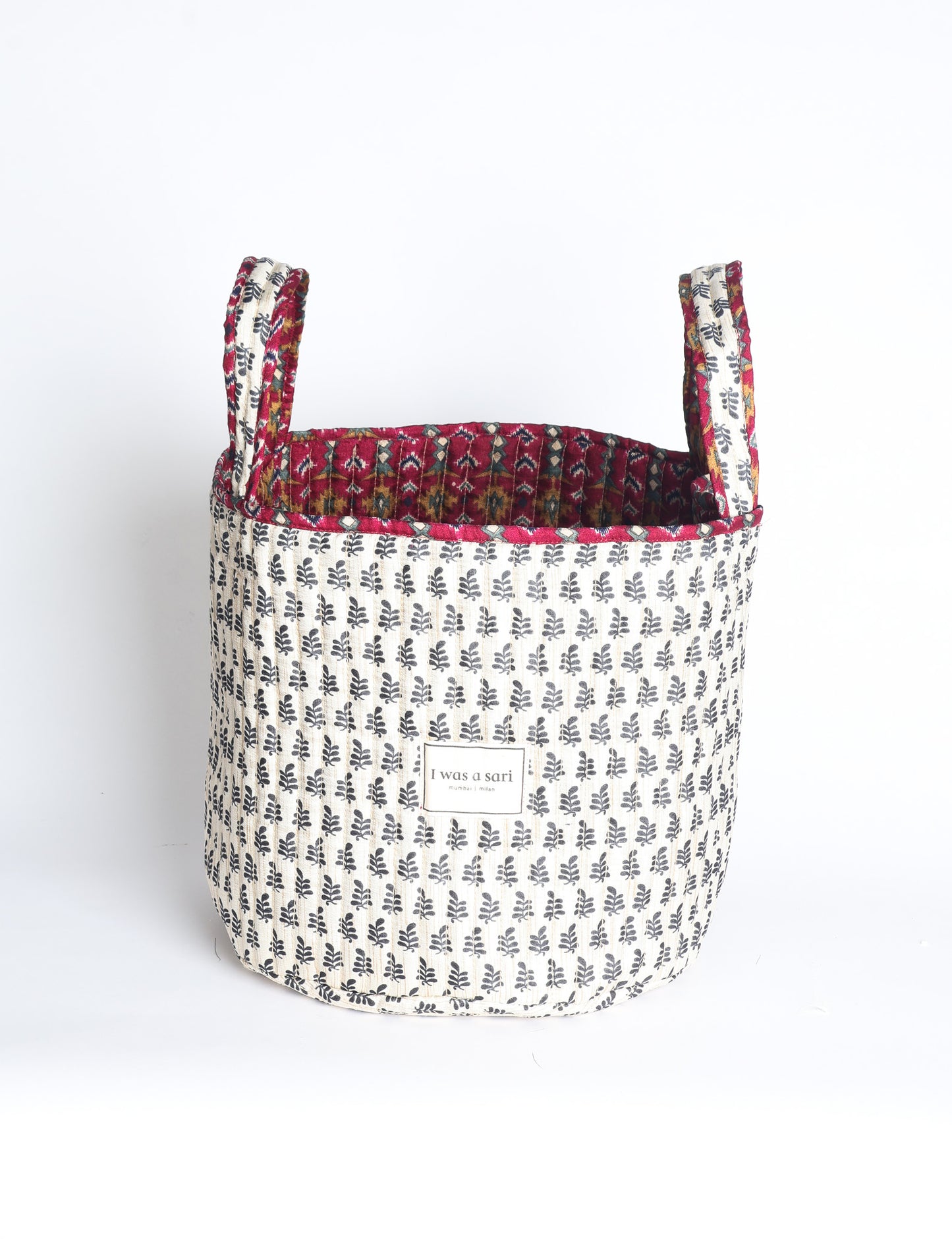 Quilted storage basket with handle in a soft cylindrical design, available in small and medium sizes for home organization.