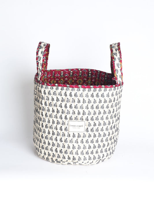 Quilted storage basket with handle in a soft cylindrical design, available in small and medium sizes for home organization.
