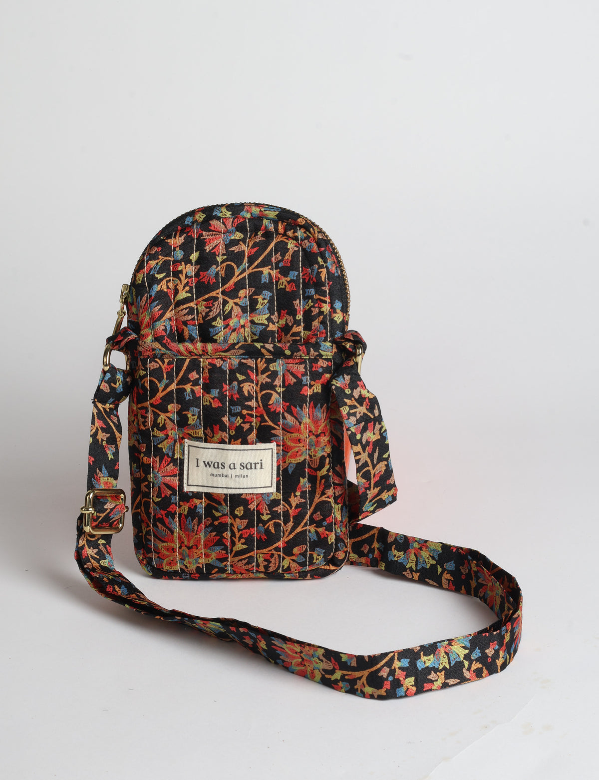 Compact quilted mobile bag featuring a padded rectangular silhouette, secure zip-top closure and adjustable crossbody strap for everyday use.