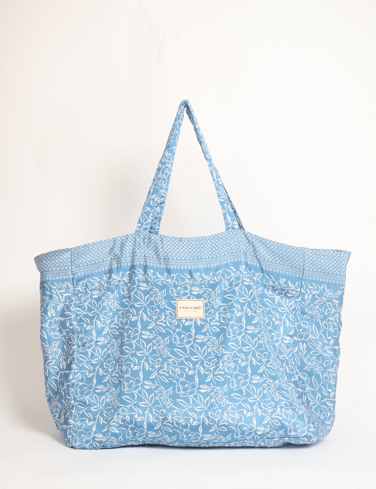 Large beach bag with a spacious rectangular design, wide top opening, and comfortable shoulder handles for carrying daily and travel essentials.