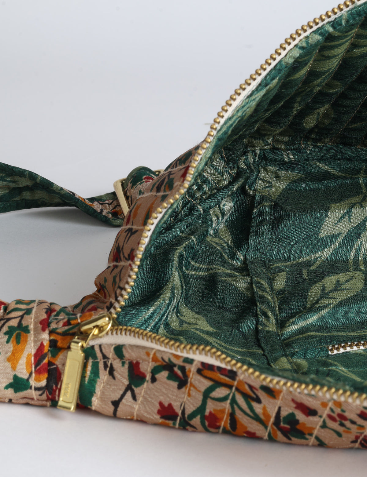 Quilted large shoulder bag with a curved silhouette, adjustable strap and zip-top closure.