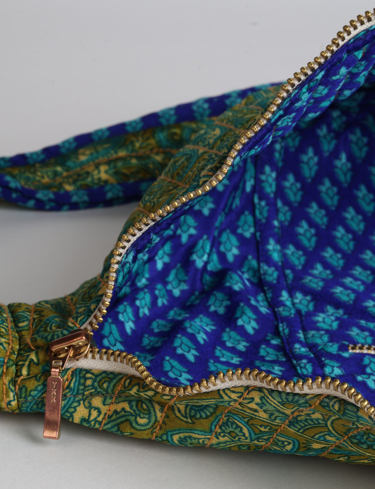 Quilted large shoulder bag with a curved silhouette, adjustable strap and zip-top closure.