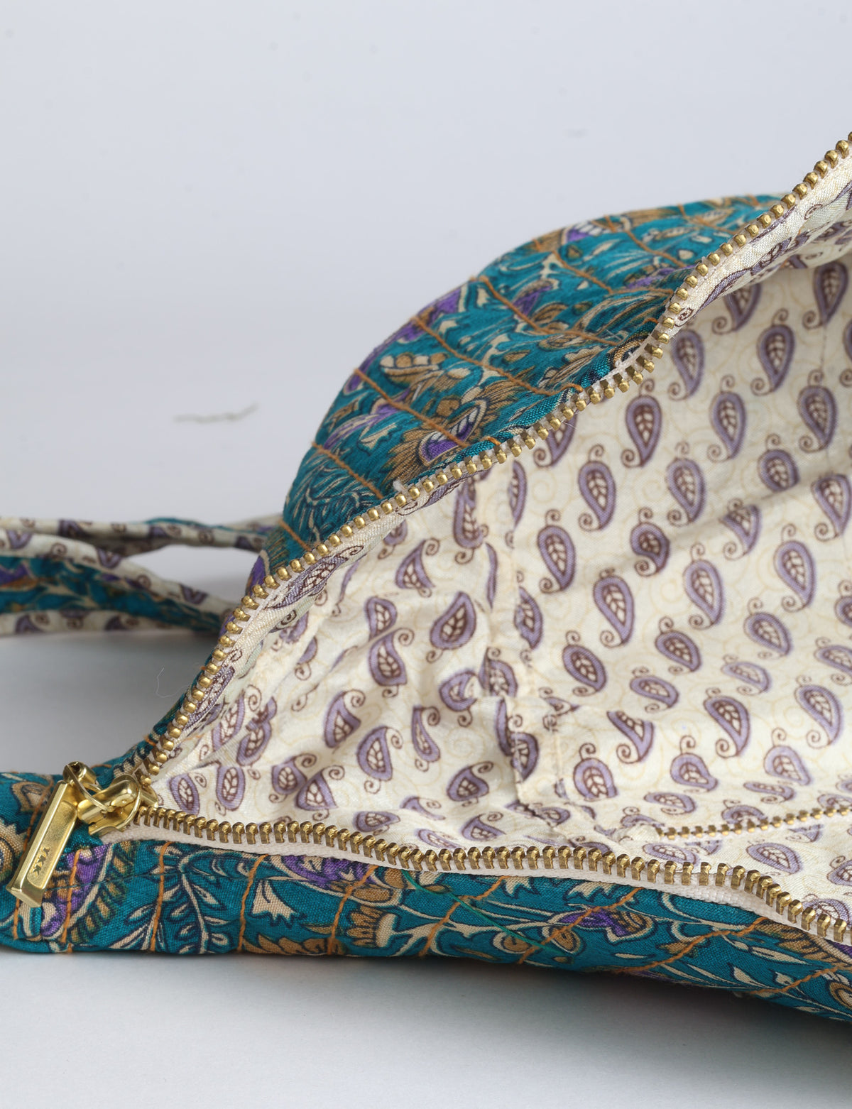 Quilted large shoulder bag with a curved silhouette, adjustable strap and zip-top closure.